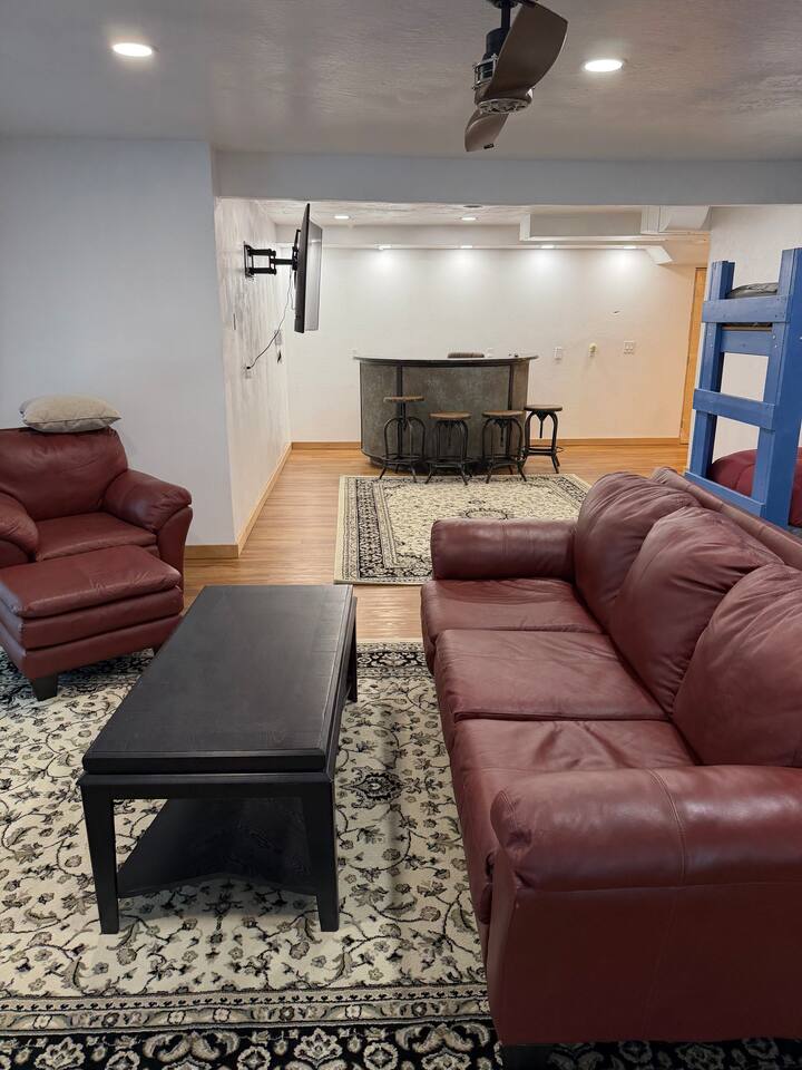 Downstairs ubatuba-topped wet bar with seating for six and leather sectional