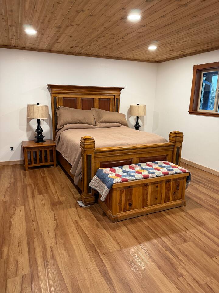 Guest bedroom with log bed frame and cedar ceiling