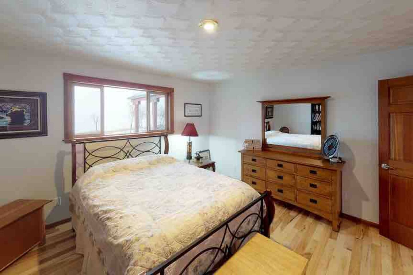 Guest bedroom with iron-frame bed and wood dresser
