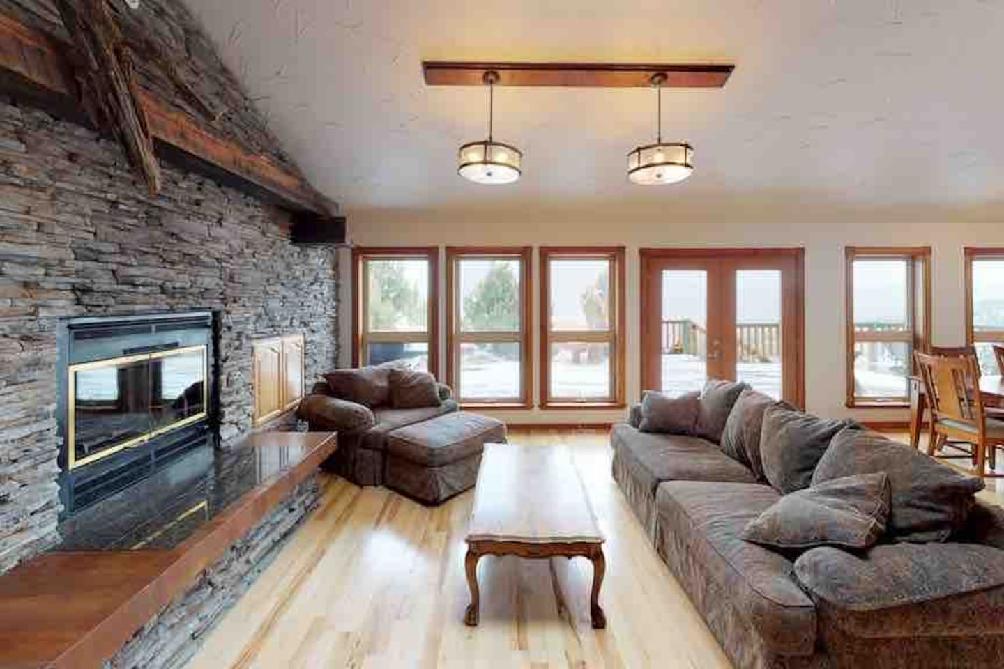 Great room with stone fireplace and French doors to the deck